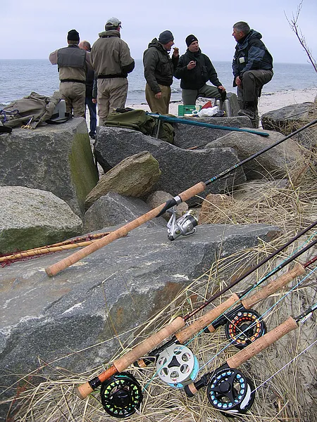 Gear talk - While the anglers gather on the beach for coffee and a chat, the gear has its own summit in the background, discussing the angler's casting faults and complaining about the aching ferrules. Notice how the spinning rod is not a part of the "fly gang" - the poor bastard.